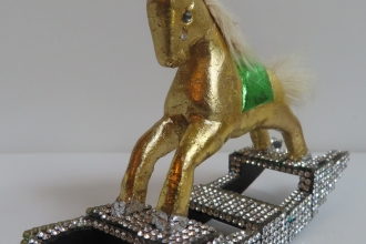 Kleines-Zirkuspferdchen 2025,  Holzfigur, Metallblatt  vergoldet mit Glitzersteine beklebt, Kopfschmuck: Ohrclip 80 er Jahre,  H 9cm,  B 12 cm